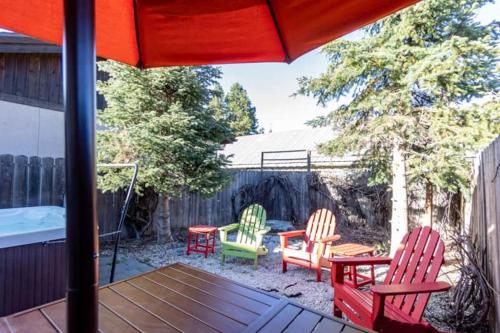 a patio with chairs and a table and an umbrella at Snowcreek Suite - Cedar - ADA- Hot Tub - Kitchenette in Leavenworth
