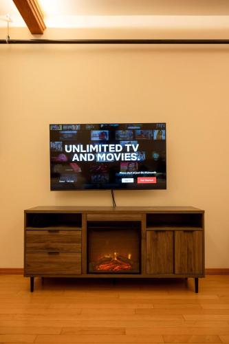 a flat screen tv sitting on top of a entertainment center at Snowcreek Suite - Cedar - ADA- Hot Tub - Kitchenette in Leavenworth