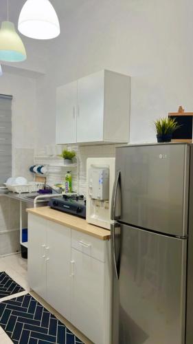 a kitchen with white cabinets and a stainless steel refrigerator at Eira Homestay Lost World Of Tambun M uslim only in Ipoh