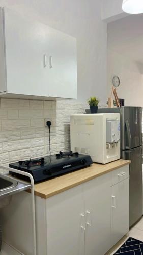 a kitchen with a stove top and a microwave at Eira Homestay Lost World Of Tambun M uslim only in Ipoh