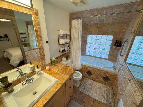 a bathroom with a sink and a toilet and a tub at Snowcreek Suite - Ponderosa in Leavenworth