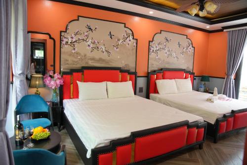 two beds in a room with orange walls at Happy Tam Coc Ecolodge in Ninh Binh