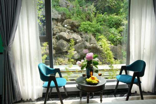 a room with two chairs and a table and a window at Happy Tam Coc Ecolodge in Ninh Binh