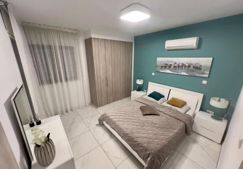 a bedroom with a bed and a blue wall at Cosmos Residence in Paralimni