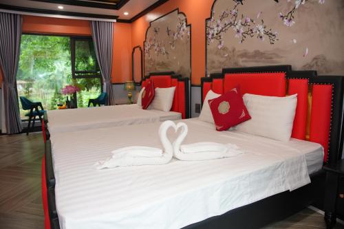 two swans sitting on two beds in a room at Happy Tam Coc Ecolodge in Ninh Binh