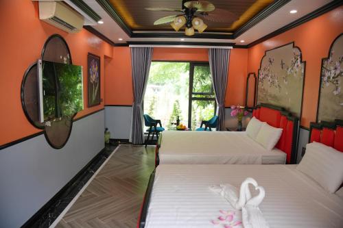 two beds in a room with orange walls at Happy Tam Coc Ecolodge in Ninh Binh