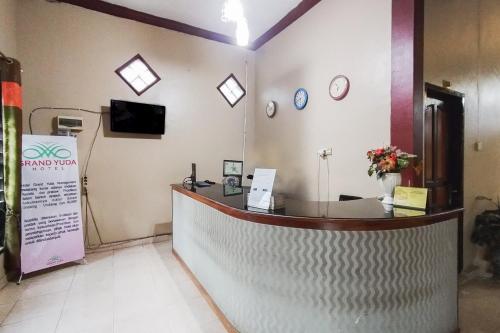 a counter in a pharmacy with clocks on the wall at RedDoorz at Hotel Grand Yuda Tenggarong in Samarinda
