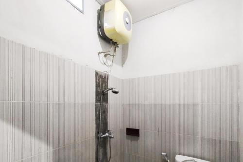 a shower in a bathroom with a wall mounted shower at RedDoorz at Hotel Grand Yuda Tenggarong in Samarinda