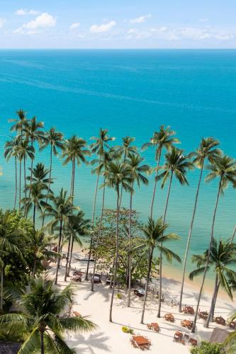 a view of a beach with palm trees and the ocean at Nikki Beach Resort & Spa Koh Samui in Lipa Noi