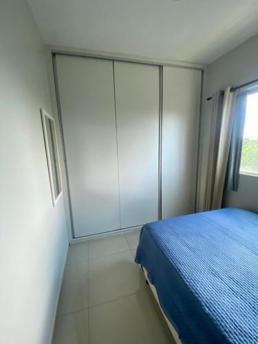a bedroom with a blue bed and a window at Lucas House in Brasilia