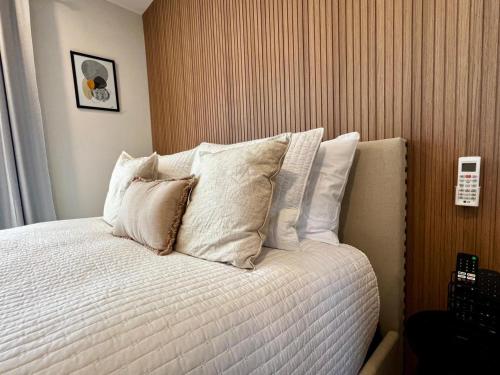 a bed with white pillows on it in a room at Loft de Lujo en Torre Punta Mayor frente a Plaza Mayor en León Gto in Miravalle