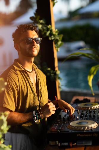 a man wearing sunglasses standing next to a table at Nikki Beach Resort & Spa Koh Samui in Lipa Noi