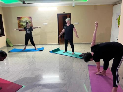 a group of people doing yoga in a room at Namasthe Ayurveda and Yoga Retreat Cochin in Nedumbassery