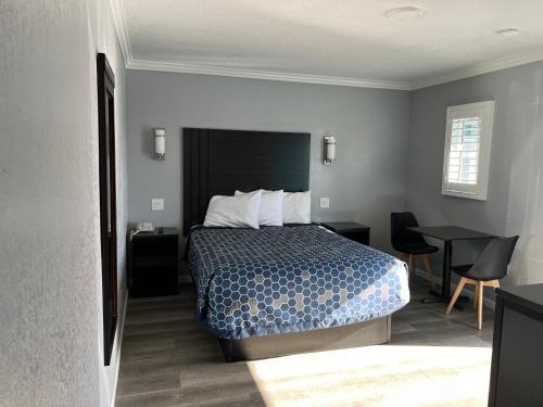 a hotel room with a bed and a table at Sea Garden Inn in Pismo Beach