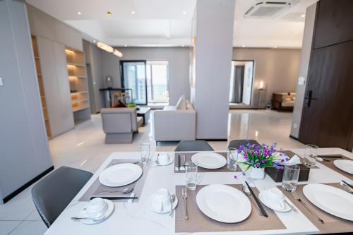 a dining room table with white plates and flowers on it at Vientiane Yooeun Hotel in Vientiane