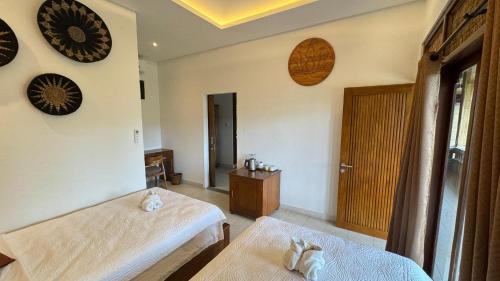 a room with two beds and clocks on the wall at Villa Karma Loka in Sidemen