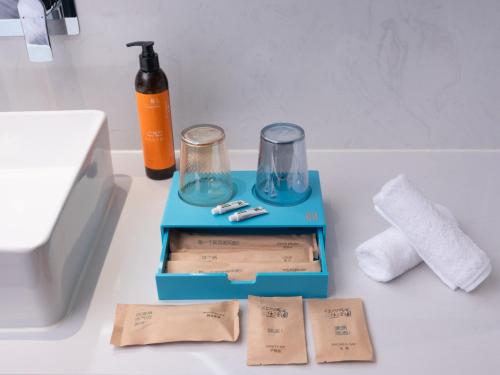 a blue box with two glasses and a bottle on a counter at CityNote Hotel -Guangzhou Beijing Road Pedestrian Street Yuexiu Park Branch in Guangzhou