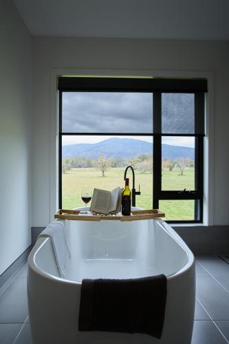 a bath tub in a room with a large window at Pomonal Estate Villas in Pomonal