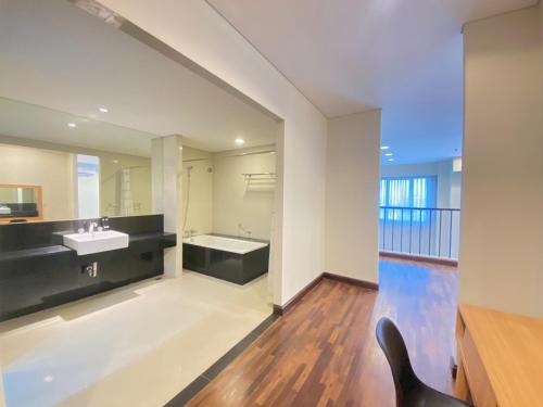 a bathroom with a sink and a bath tub at Fabulous 2BR Loft Apartment with Private Bathub at El Royale By Travelio in Bandung
