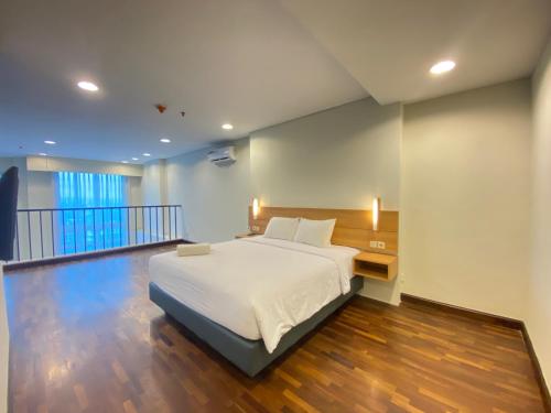 a large bedroom with a bed and a balcony at Fabulous 2BR Loft Apartment with Private Bathub at El Royale By Travelio in Bandung