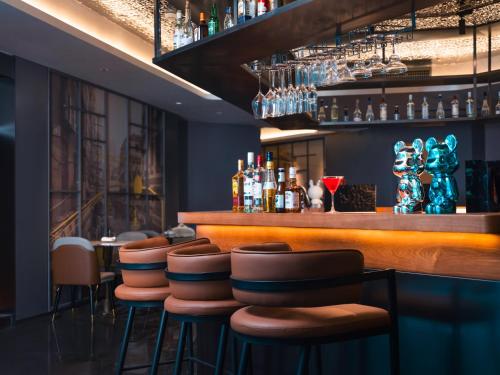 a bar with a row of stools in a restaurant at CityNote Hotel -Guangzhou Beijing Road Pedestrian Street Yuexiu Park Branch in Guangzhou