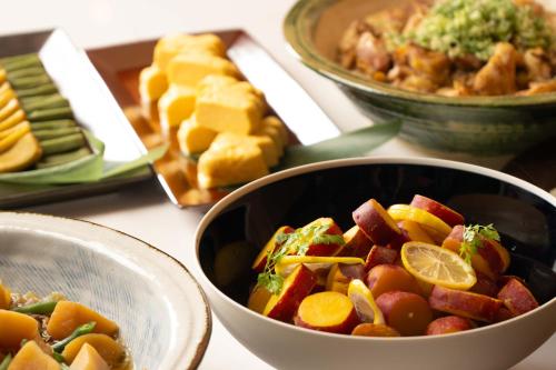 a bowl of vegetables and other foods on a table at Loisir Hotel Kyoto Toji in Kyoto
