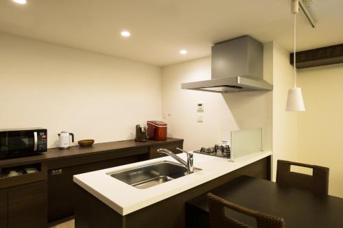 a kitchen with a sink and a microwave at アドベンチャーズアイランド 小谷流沢ロッジ in Yachimata