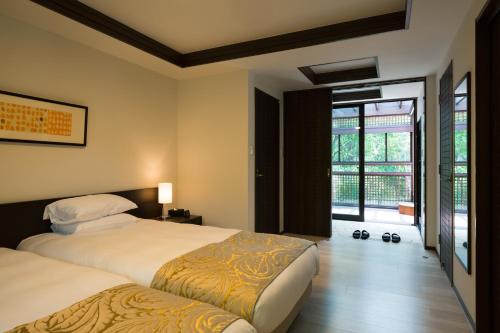 a bedroom with two beds and a large window at アドベンチャーズアイランド 小谷流沢ロッジ in Yachimata