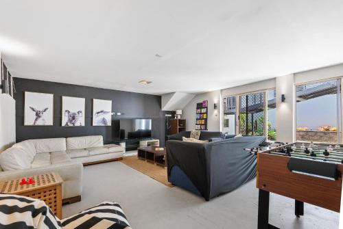 a living room filled with furniture and a game table at Breathe On Moreton will take your breath away in Tangalooma