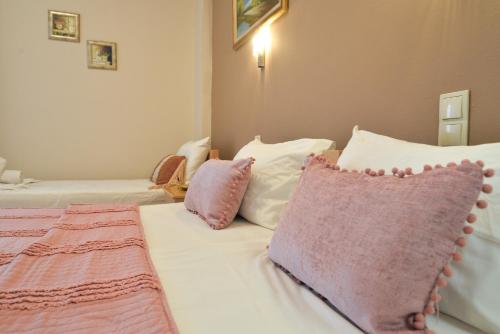 a bedroom with two beds with pink and white pillows at Εlvina apartments in Leptokaria