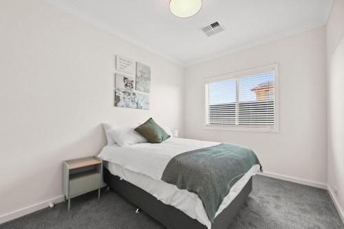 a white bedroom with a bed and a window at 29 Blanche Pd, Hindmarsh Island in Hindmarsh Island