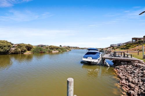 a boat is docked at a dock on a river at 29 Blanche Pd, Hindmarsh Island in Hindmarsh Island