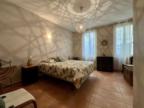 une chambre avec un lit et un lustre dans l'établissement Maison de village climatisée avec terrasse, garage privé à Argelès - FR-1-225-827, à Argelès-sur-Mer