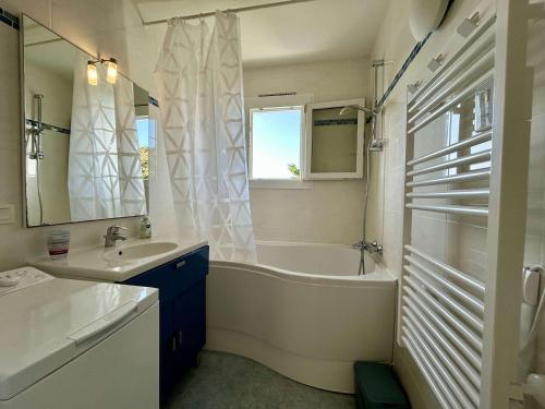 une salle de bain blanche avec une baignoire et un lavabo dans l'établissement Appartement rénové 2 pièces proche plage - La Guérinière - FR-1-224B-241, à La Guérinière