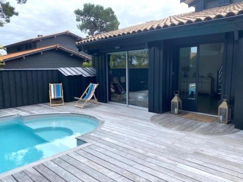 une terrasse avec une piscine et une maison dans l'établissement Villa d'exception avec terrasses spacieuses à Cap-Ferret - FR-1-736-57, à Lège-Cap-Ferret