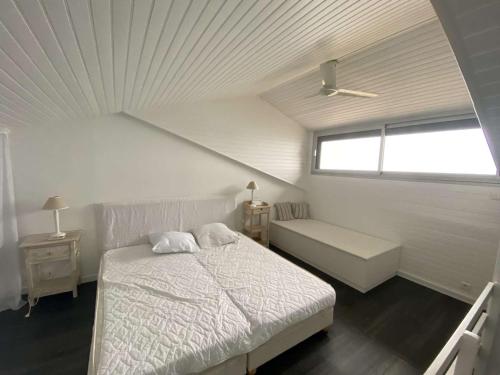 une chambre blanche avec un lit et une fenêtre dans l'établissement Villa d'exception avec terrasses spacieuses à Cap-Ferret - FR-1-736-57, à Lège-Cap-Ferret