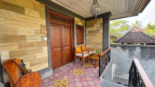 a porch of a home with a wooden door at Villa Karma Loka in Sidemen