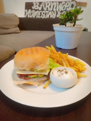 a sandwich and french fries on a white plate at Barnwood Homestay&cafe in Banaue