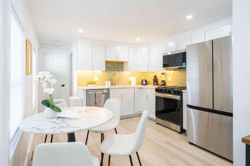 a kitchen with a table and chairs and a refrigerator at Modern East Boston 2 Bed 2 Bath in Boston
