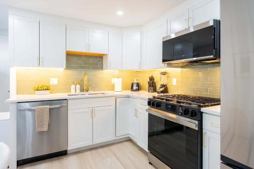 a kitchen with white cabinets and a stove top oven at Modern East Boston 2 Bed 2 Bath in Boston