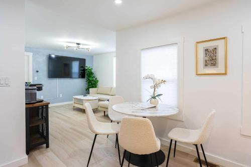 a white living room with a table and chairs at Modern East Boston 2 Bed 2 Bath in Boston