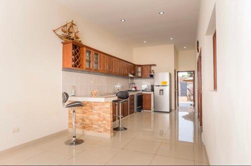 a kitchen with a counter and a refrigerator at Casa Moderna in Acajutla