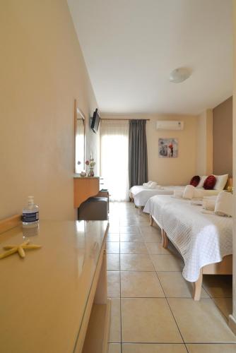 a hotel room with four beds in a row at Εlvina apartments in Leptokaria