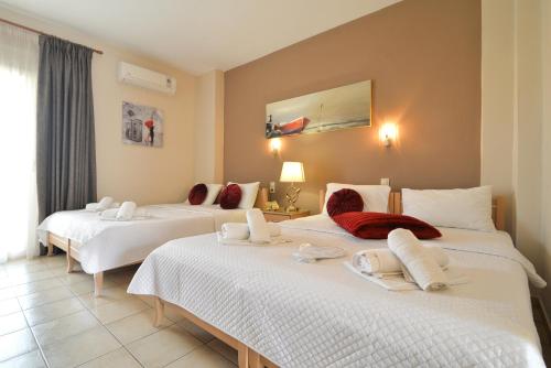 a bedroom with three beds with white sheets at Εlvina apartments in Leptokaria