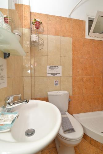 a bathroom with a sink and a toilet and a tub at Εlvina apartments in Leptokaria