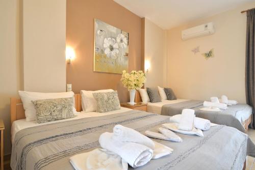 a hotel room with two beds with towels on them at Εlvina apartments in Leptokaria