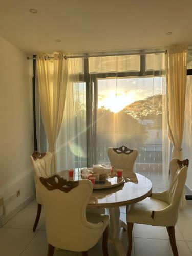 a dining room with a table and chairs and a window at Flic en Flac Luxe Seascape in Flic-en-Flac