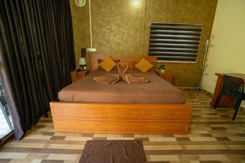 a bedroom with a wooden bed in a room at Hill Valley Farm House in Nelliyampathy