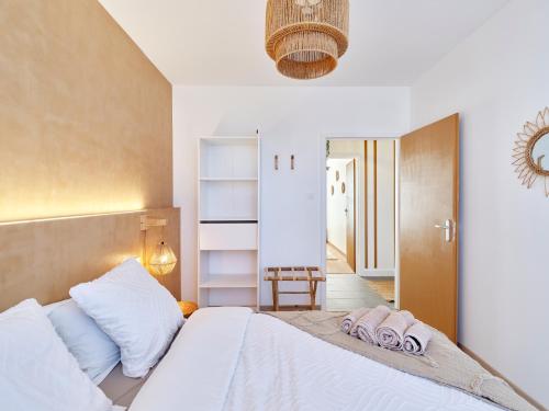 une chambre avec un lit blanc avec des serviettes dessus dans l'établissement 2BR Apartment near Colmar Centre - Boho Style, Hidden Room, Free Parking, à Colmar