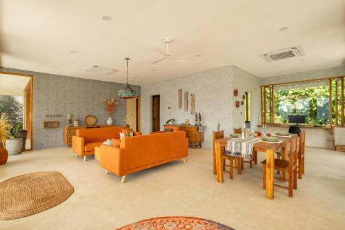 a living room with orange chairs and a table at Villa Damai Rohani in Sidemen